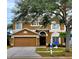 Two-story house with a brown exterior, two-car garage, and landscaping at 4027 Harbor Lake Dr, Lutz, FL 33558