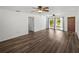 Living room with wood-look floors, ceiling fans, and sliding glass doors at 4608 S Shamrock Rd, Tampa, FL 33611