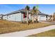 Single-story home with two-car garage, landscaping, and palm trees at 6173 Timberdale Ave, Wesley Chapel, FL 33545