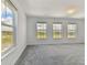 Bright bedroom with grey carpet and three windows at 6216 Golden Beach Dr, Apollo Beach, FL 33572