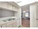 Kitchen with white appliances, view of living room and lake at 1034 Bowsprit Ln, Holiday, FL 34691