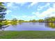 Community lake view with lush greenery and a fountain at 1034 Bowsprit Ln, Holiday, FL 34691