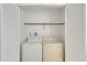 White washer and dryer in a well-lit laundry closet with shelving at 1034 Bowsprit Ln, Holiday, FL 34691