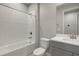 Modern bathroom with white tile, gray vanity, and a bathtub at 6162 Timberdale Ave, Wesley Chapel, FL 33545