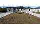 New gray house with gray pavers driveway, landscaping and palm tree at 10402 Pendleton Ave, Englewood, FL 34224