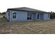 Rear view of new gray house with sliding glass doors at 10402 Pendleton Ave, Englewood, FL 34224