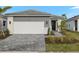 Two-car garage and walkway leading to the front entrance of a modern home at 11170 Livewell Ct, Venice, FL 34293