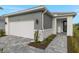 Modern home exterior with gray siding, white garage door, and a paved walkway at 11170 Livewell Ct, Venice, FL 34293