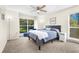 Carpeted bedroom featuring natural lighting, a ceiling fan, and two large windows at 9481 Highland Oak Dr # 512, Tampa, FL 33647