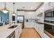 Modern kitchen with white cabinets, quartz countertops, and stainless steel appliances at 9820 Crescent Moon Dr, Riverview, FL 33578