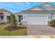 Front view of a charming light blue house with a white garage door and landscaping at 11277 Boundless Ter, Venice, FL 34293