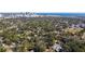 Aerial view of a residential neighborhood with lush green trees, a city skyline, and ocean views at 1565 13Th S St, St Petersburg, FL 33705