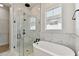 Elegant bathroom with soaking tub, walk-in shower, and marble tile at 1578 Running Tide Pl, Sarasota, FL 34240