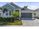 Craftsman style home with gray roof and light blue siding, two-car garage, and a paved driveway at 1578 Running Tide Pl, Sarasota, FL 34240