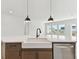 Kitchen island with farmhouse sink, quartz countertops, and black pendant lights at 1578 Running Tide Pl, Sarasota, FL 34240