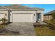 Front view of house with a paved driveway and landscaping at 11267 Boundless Ter, Venice, FL 34293