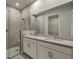 Bathroom features double vanity, gray tile shower, and white cabinets at 11275 Boundless Ter, Venice, FL 34293