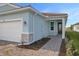 Exterior view of a light blue house with a walkway, garage, and landscaping at 11275 Boundless Ter, Venice, FL 34293