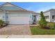 Light blue single-Gathering home with white garage door and brick paver driveway at 11275 Boundless Ter, Venice, FL 34293