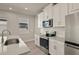 Modern kitchen with white cabinets, stainless steel appliances, and white backsplash at 11275 Boundless Ter, Venice, FL 34293