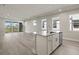 Open living room and kitchen with an island and sliding glass doors at 11275 Boundless Ter, Venice, FL 34293