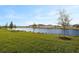 Scenic pond view with grassy area and homes in the background at 11275 Boundless Ter, Venice, FL 34293