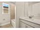 Well-lit bathroom featuring neutral tile, white cabinets and solid surface countertops and a tiled shower at 17909 Solstice Ave, Venice, FL 34293