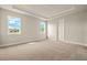 Bedroom with two windows, a tray ceiling, carpeted floors and light gray walls at 17909 Solstice Ave, Venice, FL 34293