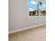 Sunlit bedroom with plush carpeting and a view to the outside showing a well-kept lawn and neighboring home at 17909 Solstice Ave, Venice, FL 34293