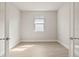 A simplistic room with a window, neutral walls, and wood-look tile flooring at 17909 Solstice Ave, Venice, FL 34293