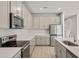 Close-up of the stylish kitchen featuring stainless steel appliances, and gray cabinets at 17909 Solstice Ave, Venice, FL 34293