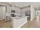 Modern kitchen with stainless steel appliances, white cabinetry, and a center island at 17909 Solstice Ave, Venice, FL 34293