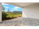 Covered patio with stone pavers, and lush backyard landscaping featuring a tranquil outdoor space at 17909 Solstice Ave, Venice, FL 34293