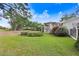 Expansive backyard featuring a white pergola, lush landscaping, and direct access to the golf course at 16407 Zurraquin De Avila, Tampa, FL 33613