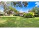 Lush backyard featuring mature trees, green grass, and an inviting screened-in outdoor sitting area at 16407 Zurraquin De Avila, Tampa, FL 33613