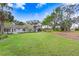 Large grassy backyard showcasing the home's exterior and private setting with mature trees and landscaping at 16407 Zurraquin De Avila, Tampa, FL 33613