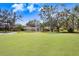 Spacious backyard with direct golf course access, mature trees, and a well-maintained lawn at 16407 Zurraquin De Avila, Tampa, FL 33613