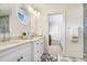 Bright bathroom with double sinks, white cabinets, decorative mirror, and access to closet at 16407 Zurraquin De Avila, Tampa, FL 33613