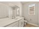 A bathroom with white cabinets, a big mirror and tile flooring at 17938 Solstice Ave, Venice, FL 34293