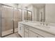 Bathroom featuring a double sink vanity with quartz countertop and glass enclosed shower at 17938 Solstice Ave, Venice, FL 34293