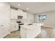 Bright, modern kitchen featuring white cabinetry, stainless steel appliances, and a central island at 17938 Solstice Ave, Venice, FL 34293