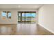 Bright living room with wood-style tile floor and sliding glass doors overlooking the lake at 17938 Solstice Ave, Venice, FL 34293