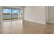 Bright living room with wood-style tile floor and sliding glass doors overlooking the lake at 17938 Solstice Ave, Venice, FL 34293