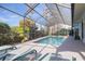 Relaxing screened pool with lounge chairs and a view of lush landscaping at 435 Palmdale Dr, Oldsmar, FL 34677