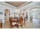 Elegant dining room with a round table, chandelier, and hardwood floors at 5205 Covesound Way, Apollo Beach, FL 33572