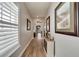 Bright hallway with hardwood floors, white shutters, and framed art at 5205 Covesound Way, Apollo Beach, FL 33572