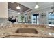 Kitchen with granite counters, sink, and view into living area and pool at 5205 Covesound Way, Apollo Beach, FL 33572