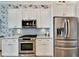 Modern kitchen with white cabinets, granite countertops, and stainless steel appliances at 5205 Covesound Way, Apollo Beach, FL 33572