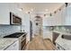 Modern kitchen with white cabinets, granite counters, and stainless steel appliances at 5205 Covesound Way, Apollo Beach, FL 33572