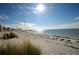 Sunny beach scene with calm water and sea oats at 1408 Riverside Dr, Tarpon Springs, FL 34689